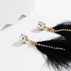 Detailed macro view of retro feather tassel earrings with black plumage and crystals