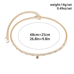 Detailed view of gold body chain with faux pearls and metal pendant showing 68cm length