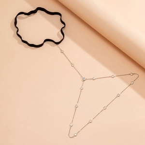 Detail of silver thigh chain with sparkling zircons and a black elastic band for beach style