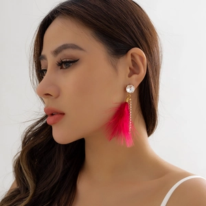 Detail of fuchsia feather earrings with crystal stud and tassel chains on model