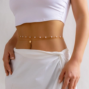 Detail view of a triple-layered gold body chain with pearls and a round disc pendant