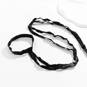Detailed close-up of black elastic lace ribbon with fine knitted texture and strap detail