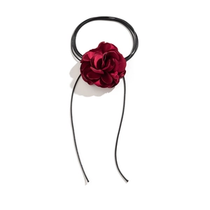 Detail of burgundy satin flower choker with layered petals and black cord ties