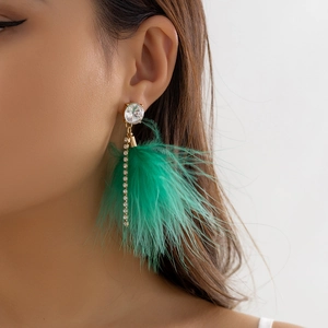 Detail shot of long feather tassel earrings with green plumage and sparkling crystals