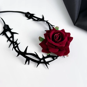 Detail van een rode fluwelen rozenchoker met een zwarte gothic fluwelen band