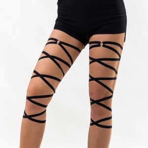 Detail of layered black elastic leg chain with silver metal ring on female thigh