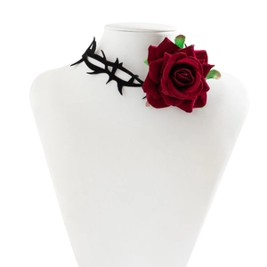 Detail van rode fluwelen roos choker met zwart doornontwerp op witte display