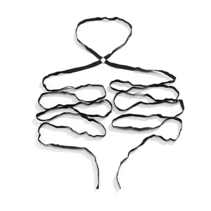 Macro detail of elastic leg harness straps and polished metal rings on white background