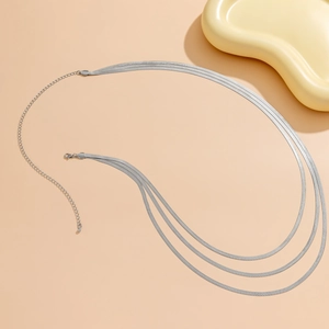 Detailed view of triple-layered silver snake chains with lobster clasp and extension