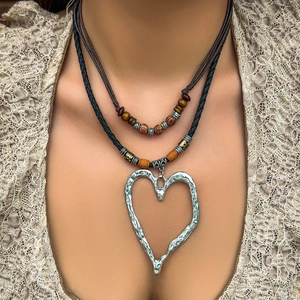 Collana boho a due strati con ciondolo a cuore grande e cordino in pelle nera intrecciata
