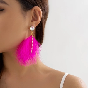Detail of rose red feather earrings with tassel chain and zircon on a female model