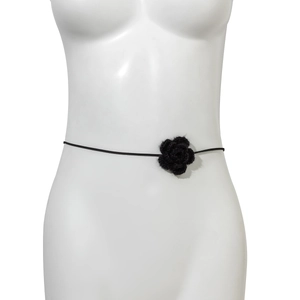 Detailopname van een zwarte fluwelen roos-choker op een witte mannequin torso