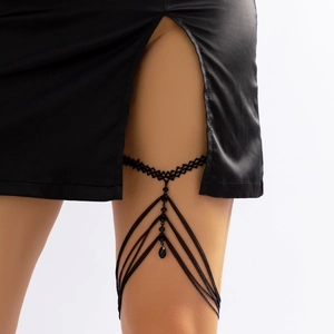 Close-up of black layered leg chain with lace band, metal chains and teardrop pendant