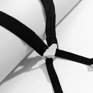 Close-up of black elastic leg chain featuring a metallic heart-shaped connector detail