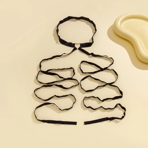 Close-up of black elastic thigh chain featuring layered bands and a metal heart buckle