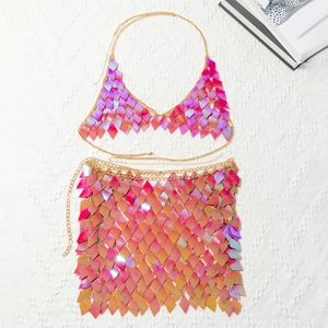 Flat lay of pink laser sequin crop top and mini skirt set with gold chain links