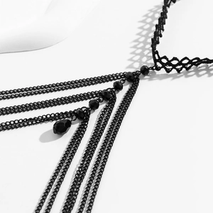 Close-up of gothic leg chain featuring black lace, layered metal chains and resin beads