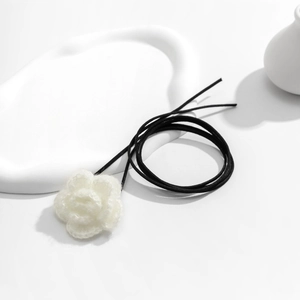 Detail van een handgemaakte witte gebreide roos choker met een zwart koordje