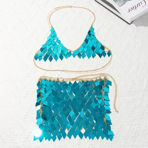 Flat lay of shimmering turquoise sequin bikini top and skirt with gold chain links