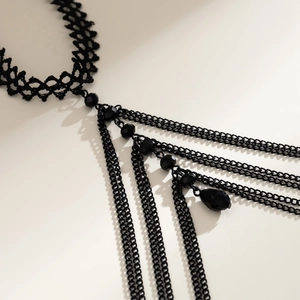 Detail of gothic black lace choker with multi-layer metal chains and beaded charms