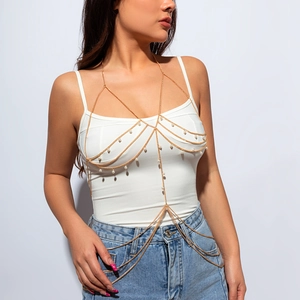 Detail of gold multi-layer body chain featuring elegant pearls and a cross-wrap design