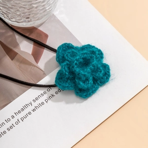 Detail van de handgehaakte donker cyaan bloemen choker met een dun zwart koord