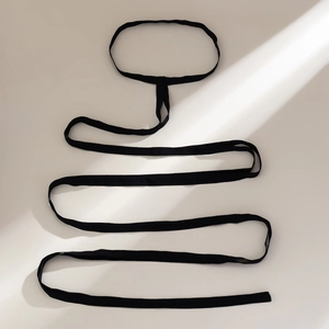 Close-up detail of flexible black elastic leg chain strap with a soft fabric texture