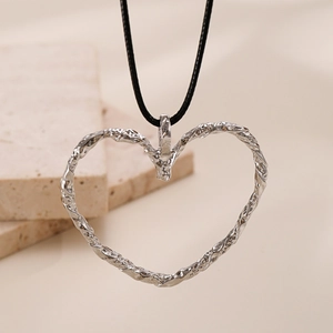 Dettaglio del grande ciondolo a cuore argento con trama lavica su collana in corda nera