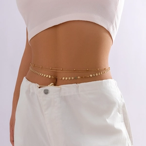 Détail d'une chaîne de taille dorée à plusieurs rangs avec paillettes sur mannequin
