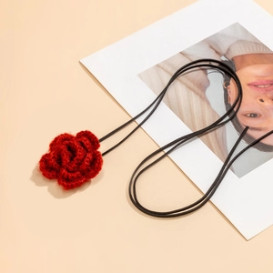 Detail van rode gehaakte roos choker met handgemaakte fluwelen textuur op koord