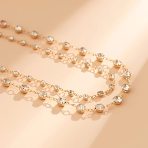 Chaîne de corps dorée à double couche élégante avec strass brillants sur fond minimaliste