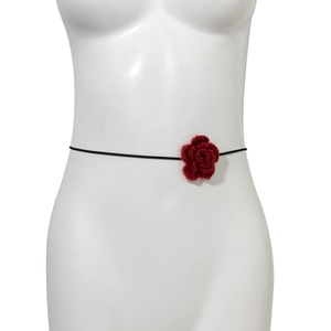 Detail van een grote rode fluwelen rozenchoker met zwart koord op een paspop