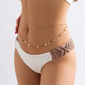 Détail d'une chaîne de corps dorée bohème à double rangée avec pendentifs en feuilles