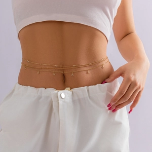 Détail d'une chaîne de taille dorée multicouche avec zircons et pendentifs ronds
