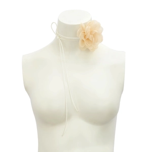 Detail of elegant champagne fabric flower choker with long white ribbons on a mannequin