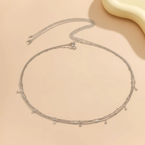 Détail d'une chaîne de corps argentée à plusieurs rangs avec pendentifs strass