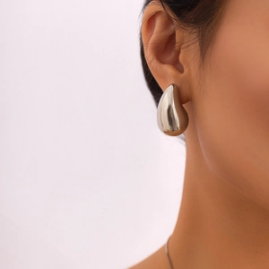 Detailed view of polished silver waterdrop earring on model with mirror finish