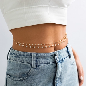 Détail d'une chaîne de taille dorée à double rangée avec strass sur un mannequin femme