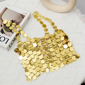 Nahaufnahme der goldenen Paillettenweste mit glänzenden Metallscheiben und Kettengliedern