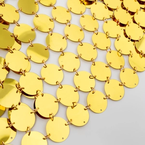 Nahaufnahme des goldenen Paillettennetzes mit spiegelnden Scheiben und Metallringen