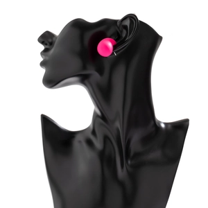 Hot pink round stud earrings with matte texture on a black display stand