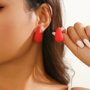 Macro shot of matte red teardrop earrings showing smooth texture and elegant drop design