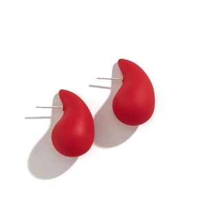 Macro shot of minimalist matte red teardrop earrings with smooth asymmetrical curves