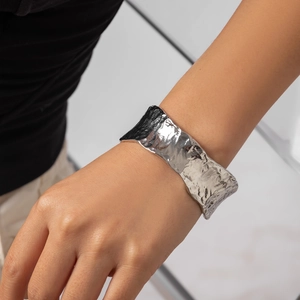 Bracciale rigido largo in argento martellato con design punk minimalista e texture