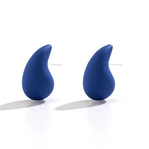 Close-up of matte Klein blue water drop stud earrings with minimalist curved design