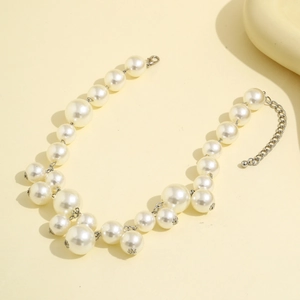 Detail van een witte parel choker met verstelbare zilverkleurige karabijnsluiting