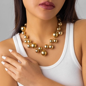Detailopname van een dikke gouden kralenketting gedragen door een vrouwelijk model