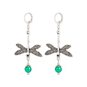 Macro view of vintage silver dragonfly earrings featuring hollow wings and green beads