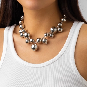 Detailopname van gedurfde zilveren metalen bollen op een choker met een spiegelglans