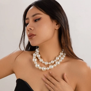 Macro detail of double-layered oversized pearl choker necklace on a female model